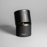 Hinoki candle in a black minimalist tin, featuring a rich, resinous wood aroma with a distinctive brightness. Infused with blue cypress, rose, yuzu, and balanced essential oils for a fresh, welcoming scent. Made with coconut/soy wax, essential oils, and botanical extracts.