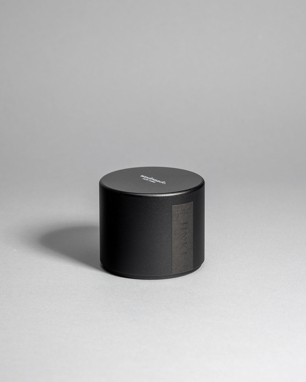 Hinoki candle in a black minimalist tin, featuring a rich, resinous wood aroma with a distinctive brightness. Infused with blue cypress, rose, yuzu, and balanced essential oils for a fresh, welcoming scent. Made with coconut/soy wax, essential oils, and botanical extracts.