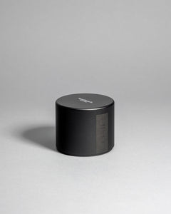 Hinoki candle in a black minimalist tin, featuring a rich, resinous wood aroma with a distinctive brightness. Infused with blue cypress, rose, yuzu, and balanced essential oils for a fresh, welcoming scent. Made with coconut/soy wax, essential oils, and botanical extracts.