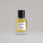 ATLS Atlas 50 mL botanical perfume in a minimalist glass bottle with a matte black cap and golden hue, set against a pale gray backdrop.