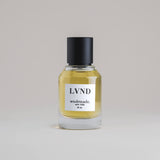 LVND Lavender 50 mL botanical perfume in a minimalist glass bottle with a matte black cap and golden hue, set against a pale gray backdrop.