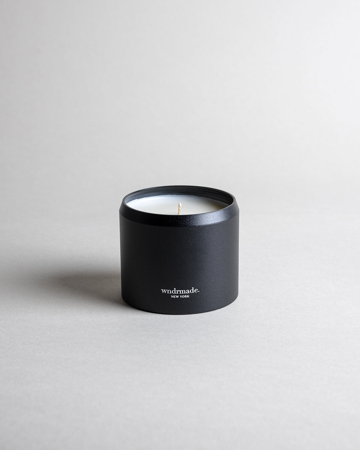 Vetiver candle in a black minimalist tin, featuring a soft, warm, and cozy aroma, reminiscent of your favorite cashmere sweater. A comforting scent that creates a soothing atmosphere for moments of pure relaxation. Made with coconut/soy wax, essential oils, and botanical extracts.