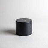 Vetiver candle in a black minimalist tin, featuring a soft, warm, and cozy aroma, reminiscent of your favorite cashmere sweater. A comforting scent that creates a soothing atmosphere for moments of pure relaxation. Made with coconut/soy wax, essential oils, and botanical extracts.