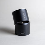 Vetiver candle in a black minimalist tin, featuring a soft, warm, and cozy aroma, reminiscent of your favorite cashmere sweater. A comforting scent that creates a soothing atmosphere for moments of pure relaxation. Made with coconut/soy wax, essential oils, and botanical extracts.