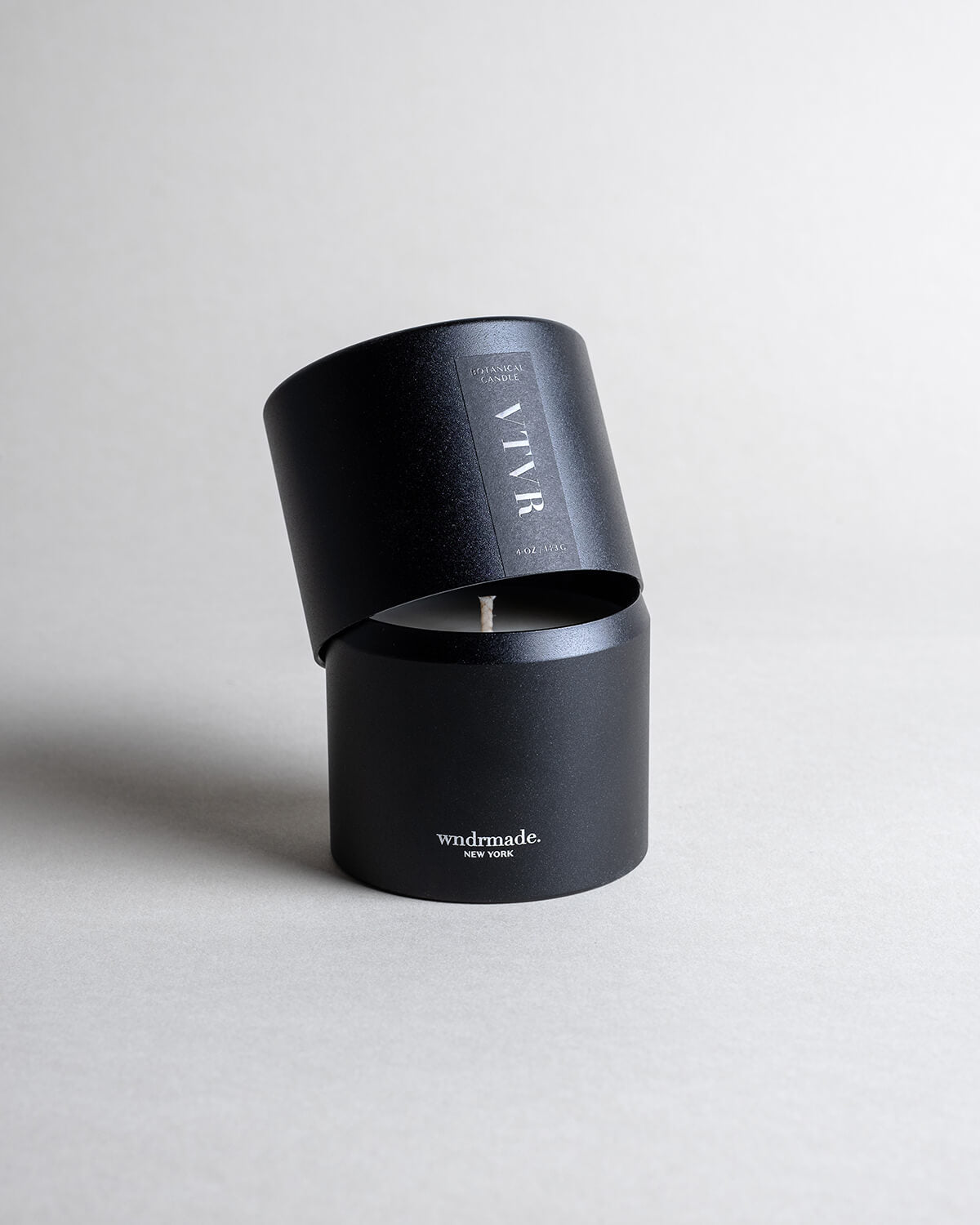 Vetiver candle in a black minimalist tin, featuring a soft, warm, and cozy aroma, reminiscent of your favorite cashmere sweater. A comforting scent that creates a soothing atmosphere for moments of pure relaxation. Made with coconut/soy wax, essential oils, and botanical extracts.