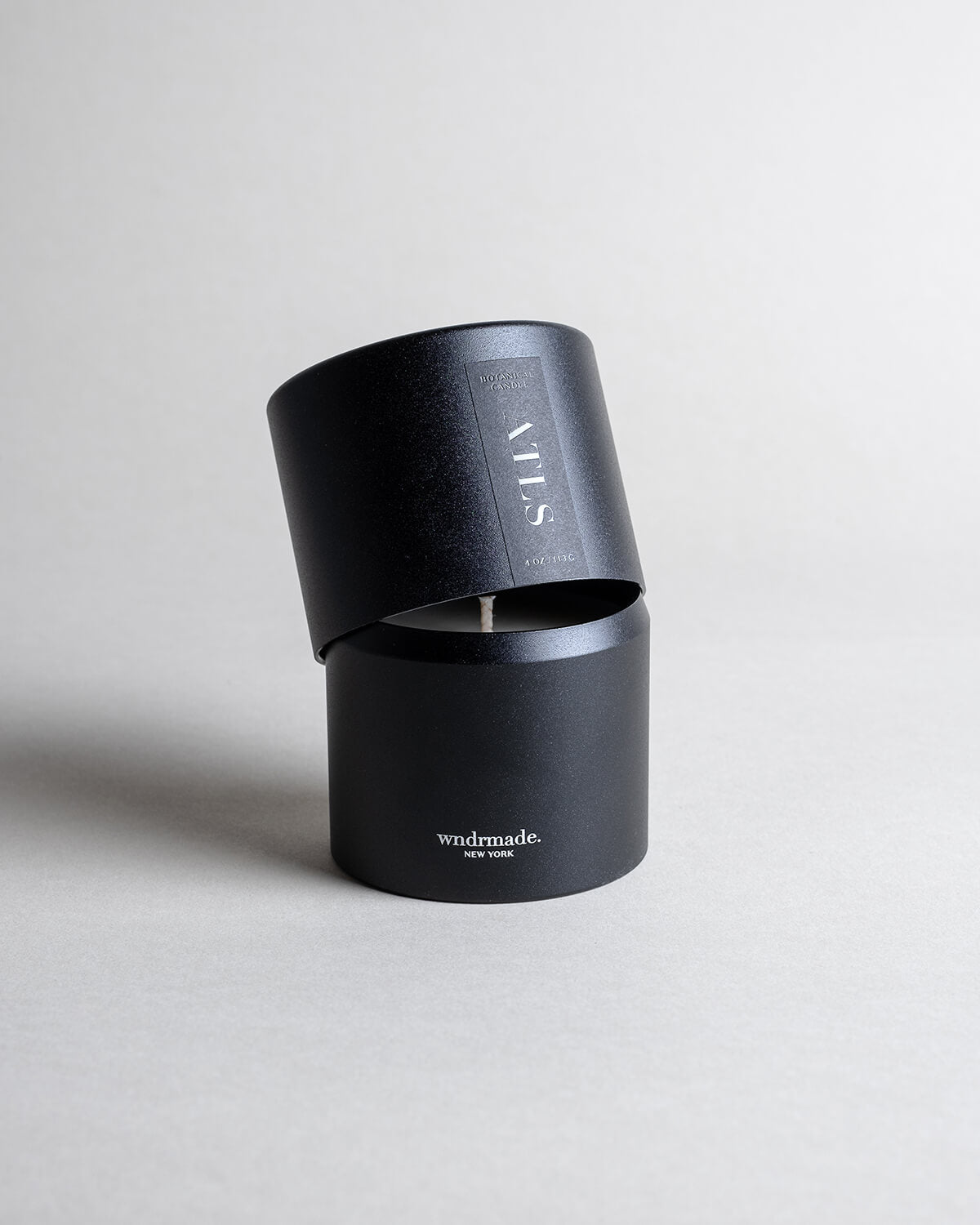 ATLAS candle in a black minimalist tin, evoking a dreamy walk through Moroccan cedar forests with a light citrus blossom breeze. A soft, woodsy, and mildly sweet design, crafted to calm the mind. Made with coconut/soy wax, essential oils, and botanical extracts.