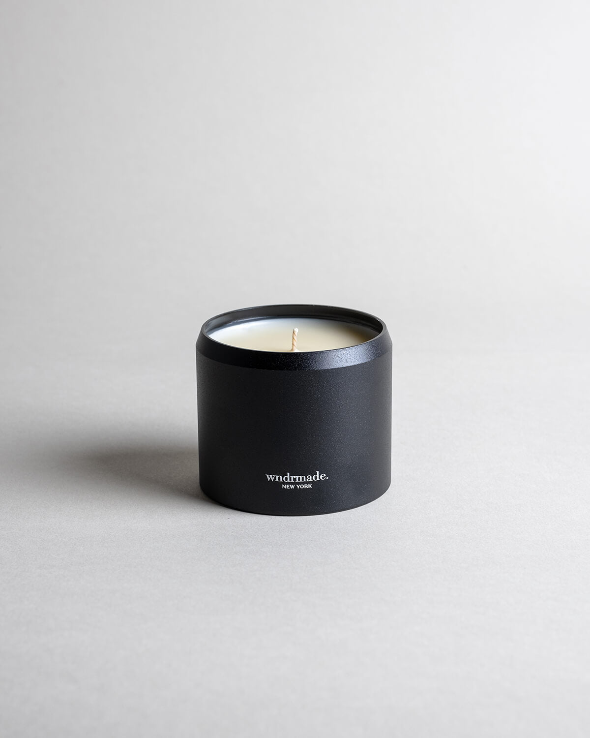 Jasmine candle in a black minimalist tin, featuring a sultry, seductive, honey-sweet aroma with natural complexity. Both arousing and calming, this scent celebrates intimate moments. Made with coconut/soy wax, essential oils, and botanical extracts.